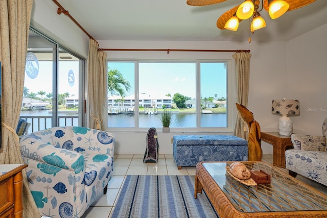 living room with light tile flooring, ceiling fan, and a water view