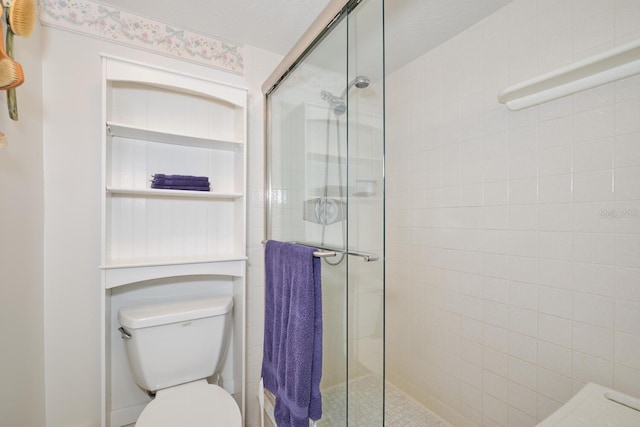 bathroom featuring an enclosed shower and toilet