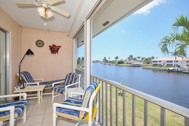 balcony with ceiling fan and a water view