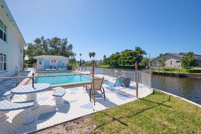 view of pool featuring a water view, a yard, and a patio