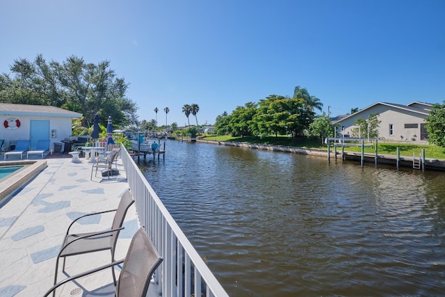 dock area with a patio, a pool, and a water view