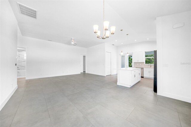 interior space with lofted ceiling, sink, and ceiling fan with notable chandelier