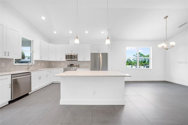 kitchen with stainless steel appliances, hanging light fixtures, a center island, and white cabinets