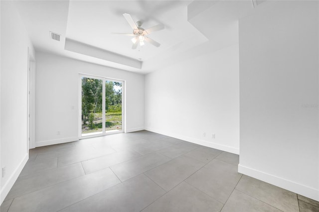 spare room featuring ceiling fan and a raised ceiling