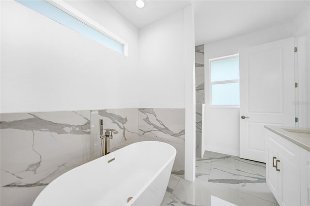 bathroom featuring vanity, tile walls, and a washtub