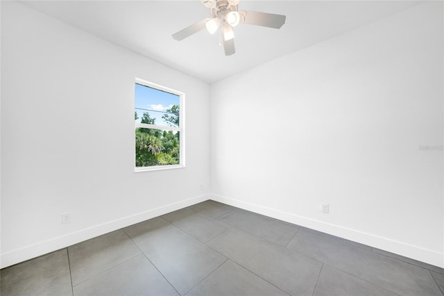 tiled empty room featuring ceiling fan