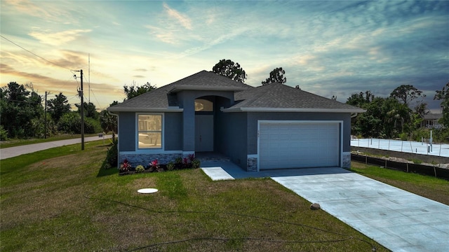 view of front facade with a garage and a lawn