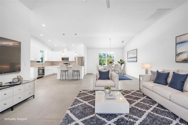 tiled living room featuring lofted ceiling and a notable chandelier