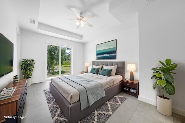 bedroom featuring a raised ceiling, access to outside, ceiling fan, and light tile patterned floors