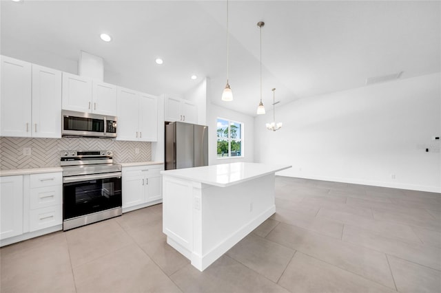 kitchen featuring decorative light fixtures, stainless steel appliances, a center island, and white cabinets