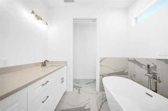 bathroom with vanity, a bathtub, and tile walls