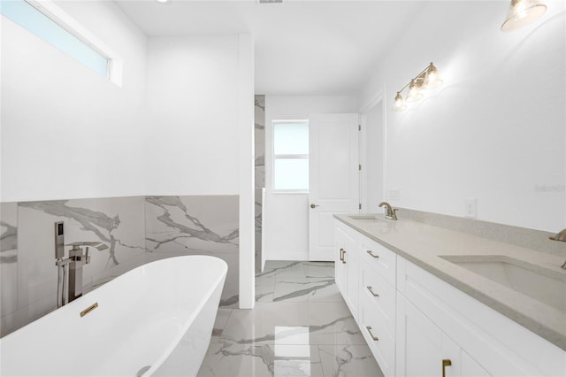 bathroom featuring tile walls, a tub to relax in, vanity, and a wealth of natural light