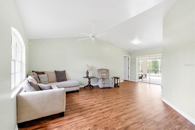 living room with ceiling fan, wood-type flooring, and vaulted ceiling