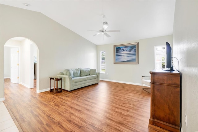 living room featuring ceiling fan, lofted ceiling, and light wood-type flooring