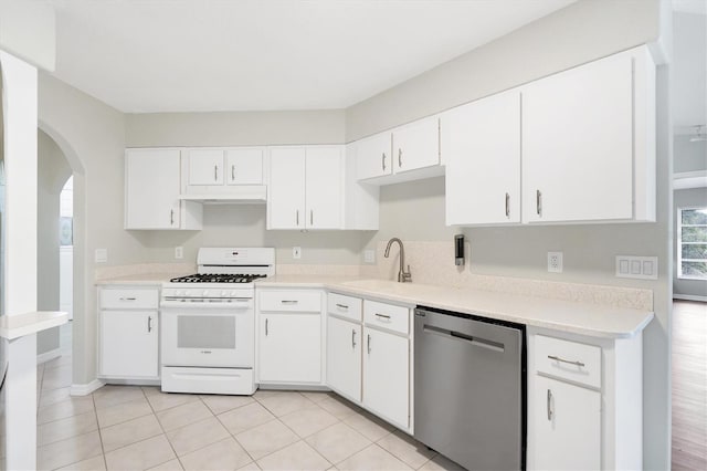 kitchen featuring gas range gas stove, sink, white cabinets, stainless steel dishwasher, and light tile patterned flooring