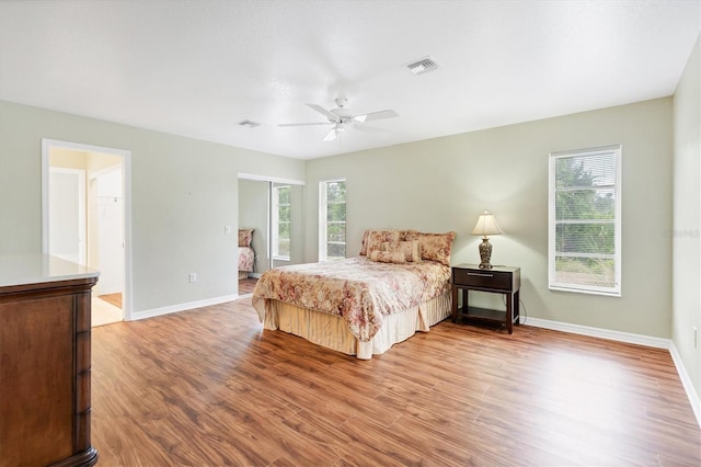 bedroom with multiple windows, hardwood / wood-style flooring, and ceiling fan