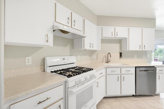 kitchen with white gas range oven, stainless steel dishwasher, sink, light tile patterned floors, and white cabinets