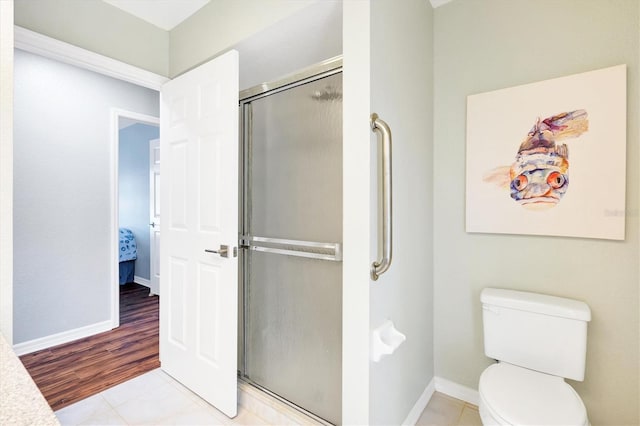 bathroom with wood-type flooring, an enclosed shower, and toilet