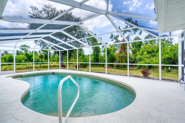 view of pool with glass enclosure and a patio