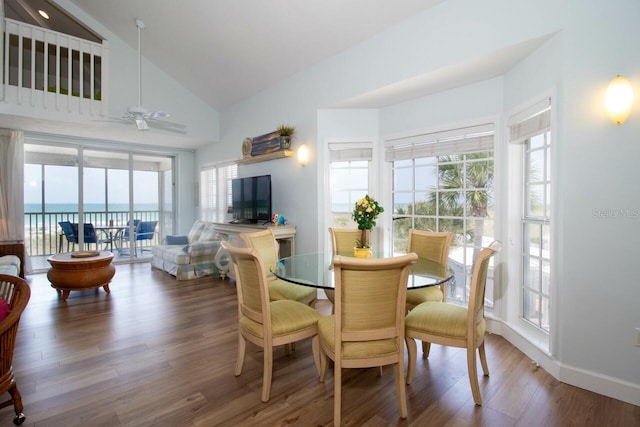 dining area featuring ceiling fan, a healthy amount of sunlight, a water view, and wood-type flooring