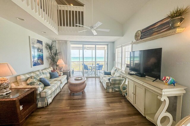 living room with high vaulted ceiling, ceiling fan, a water view, and hardwood / wood-style floors