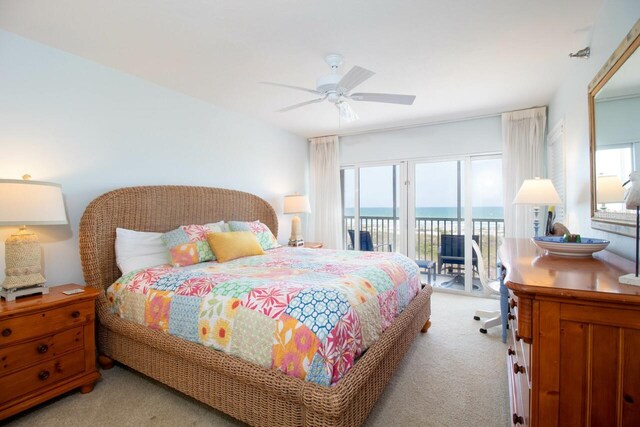 carpeted bedroom featuring a water view, ceiling fan, and access to exterior