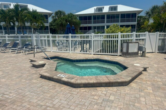 view of swimming pool featuring a hot tub