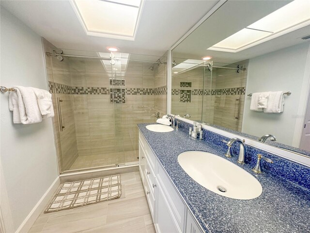 bathroom with tile flooring, vanity with extensive cabinet space, a shower with shower door, and double sink