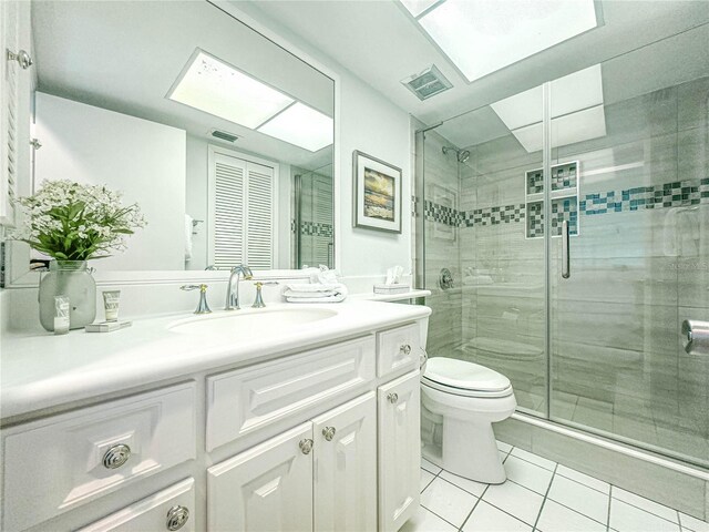 bathroom with walk in shower, tile flooring, toilet, and vanity