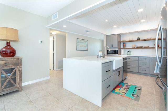 kitchen with a kitchen island with sink, light tile flooring, gray cabinetry, stainless steel appliances, and sink