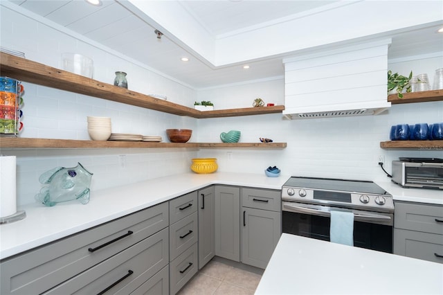 kitchen featuring stainless steel range with electric stovetop, tasteful backsplash, light tile floors, and gray cabinets