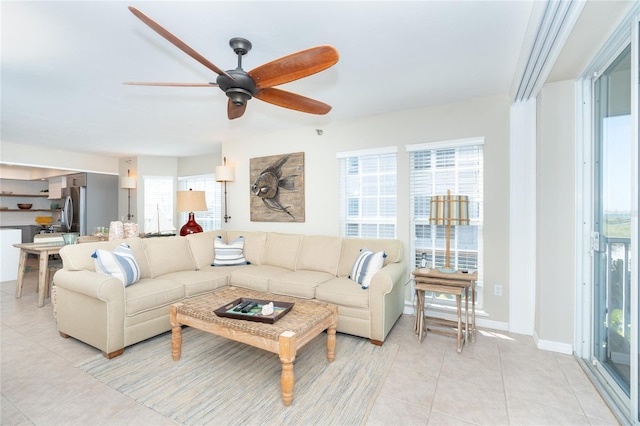 tiled living room with a wealth of natural light and ceiling fan