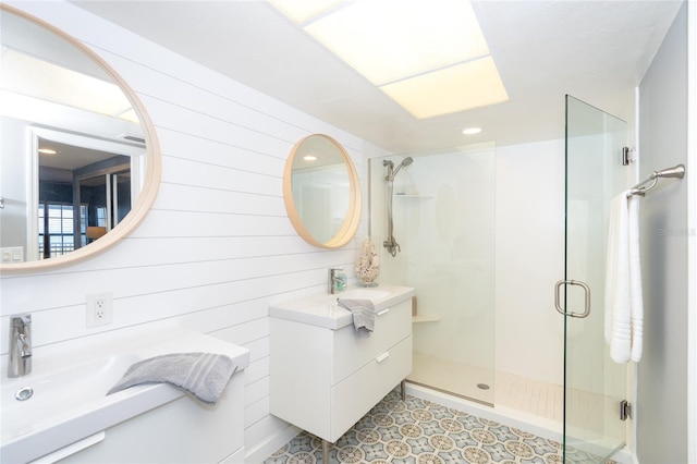 bathroom with a shower with door, tile flooring, wood walls, and large vanity