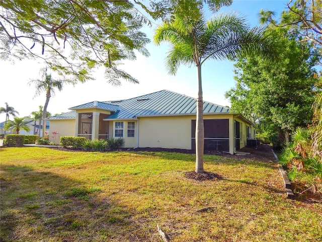 view of side of property featuring cooling unit and a lawn