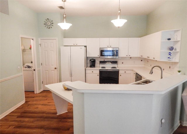 kitchen with hanging light fixtures, washer / dryer, hardwood / wood-style floors, and white appliances