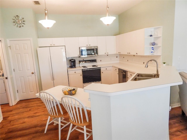 kitchen with stainless steel appliances, sink, kitchen peninsula, pendant lighting, and dark hardwood / wood-style flooring