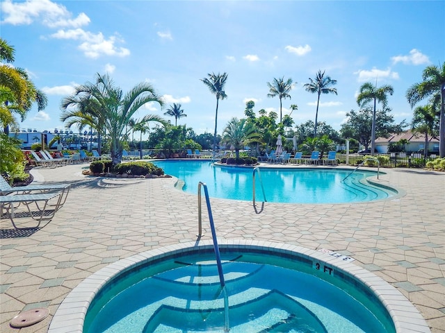 view of swimming pool featuring a patio area and a hot tub