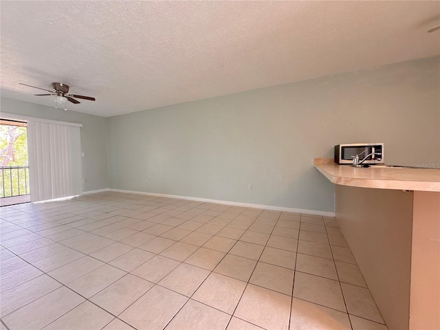 tiled empty room with a textured ceiling and ceiling fan