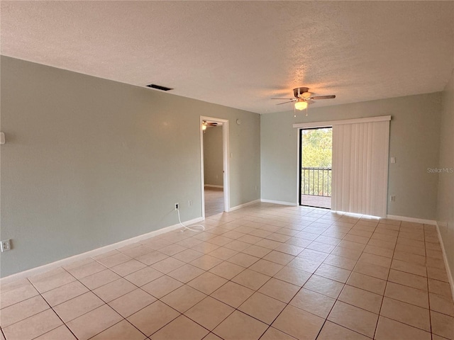 tiled spare room with a textured ceiling and ceiling fan