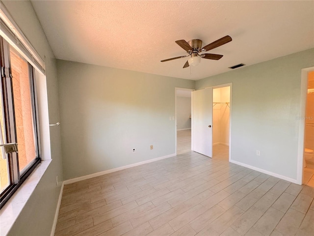 unfurnished room featuring ceiling fan and a textured ceiling