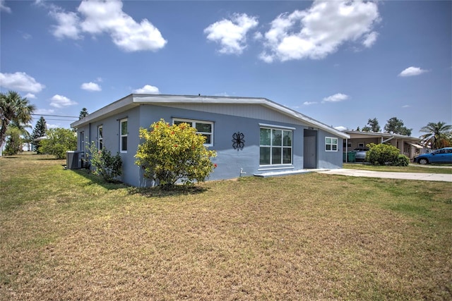 view of front of house with a front lawn and central air condition unit