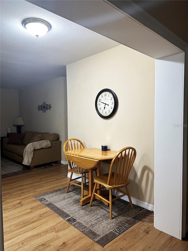 dining area featuring hardwood / wood-style floors and a textured ceiling