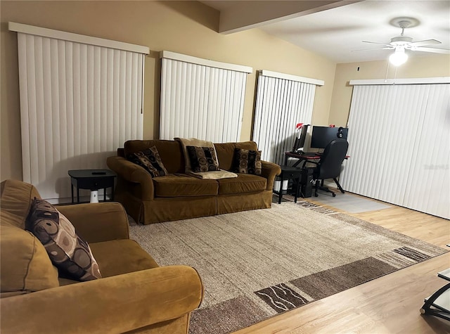 living room featuring hardwood / wood-style floors, ceiling fan, and lofted ceiling with beams