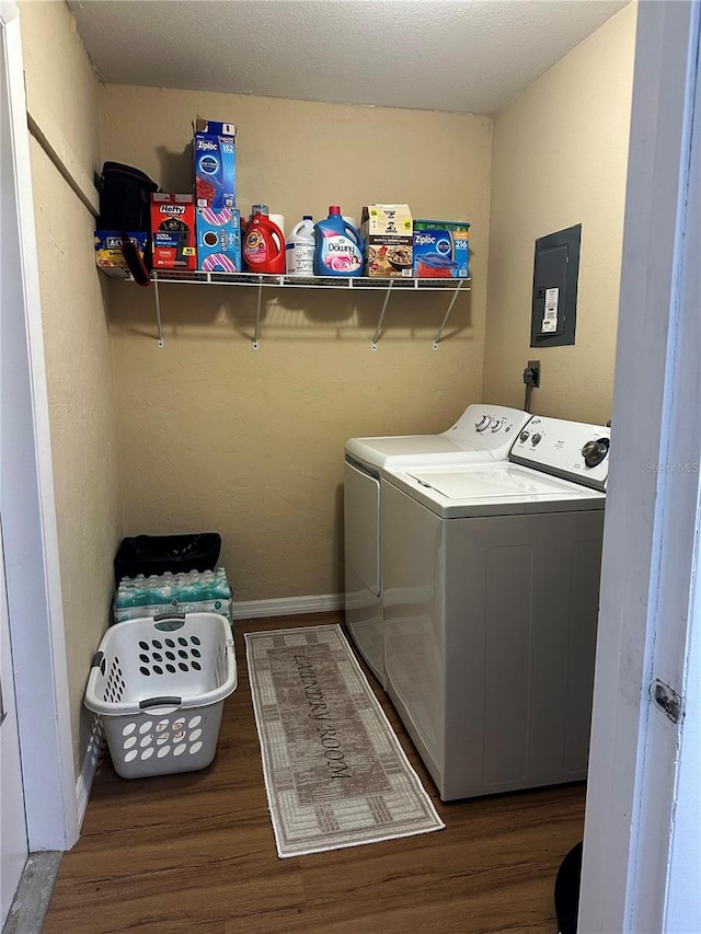 washroom with hookup for an electric dryer, dark hardwood / wood-style floors, and washing machine and clothes dryer