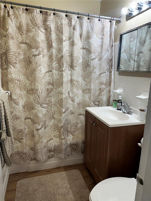 bathroom with hardwood / wood-style floors, vanity, and toilet