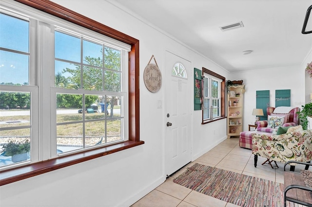 tiled entryway with a wealth of natural light and ornamental molding