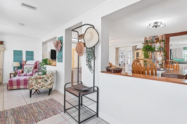 interior space featuring a healthy amount of sunlight, ornamental molding, and french doors