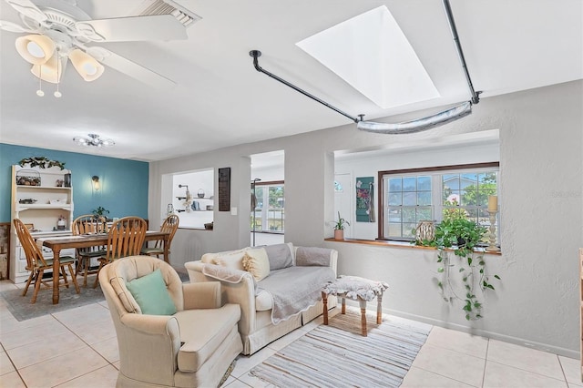 living room featuring ceiling fan, plenty of natural light, and light tile flooring