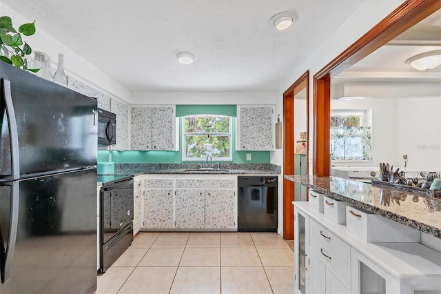 kitchen with white cabinets, black appliances, sink, and light tile flooring