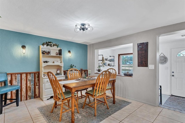 dining area with plenty of natural light, a textured ceiling, and light tile flooring